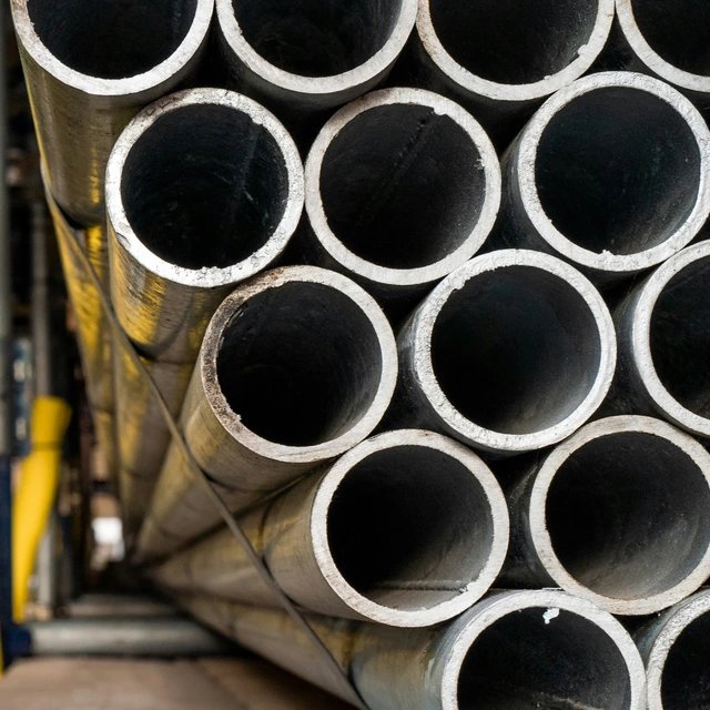 Stapel großer Metallrohre von vorne gesehen, typischerweise verwendet in Rohrleitungen, Bauwesen oder industriellen Systemen.